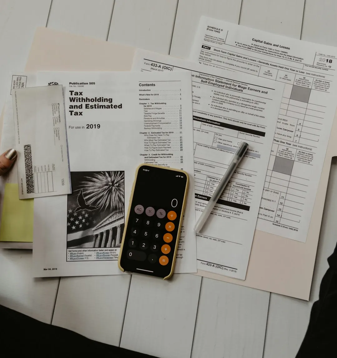 Documentos, calculadora y bolígrafo sobre la mesa