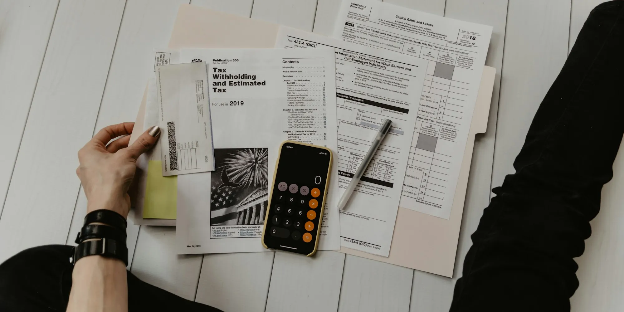 Documentos, calculadora y bolígrafo sobre la mesa