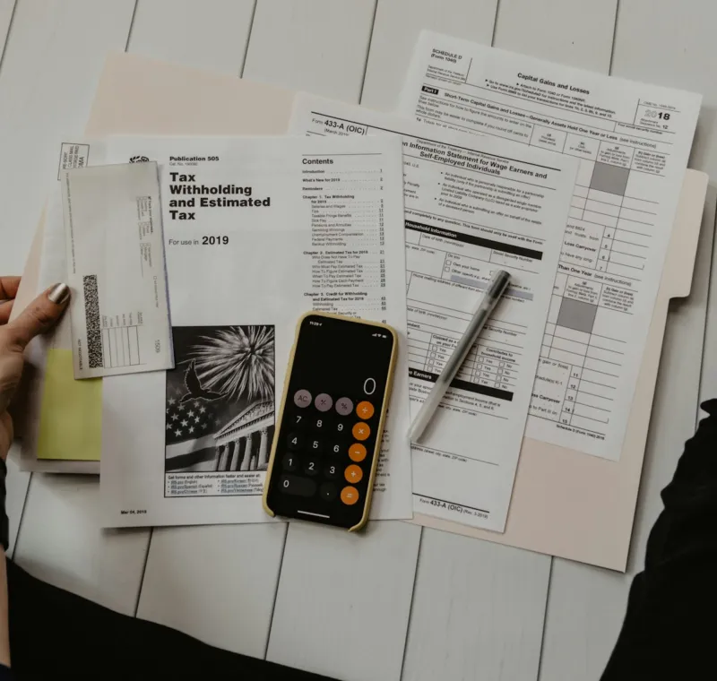 Documentos, calculadora y bolígrafo sobre la mesa
